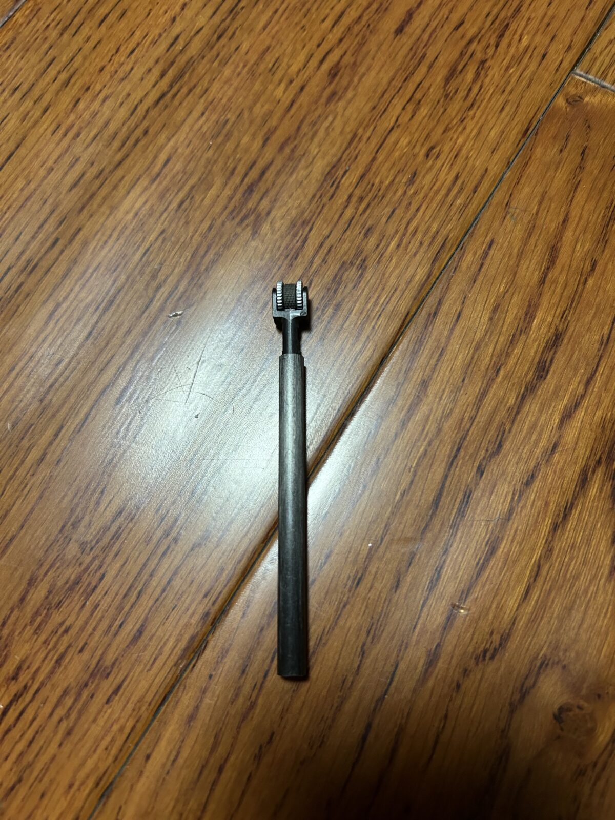 金属筒状轻量化户外打火器的双滚轮点火头特写。